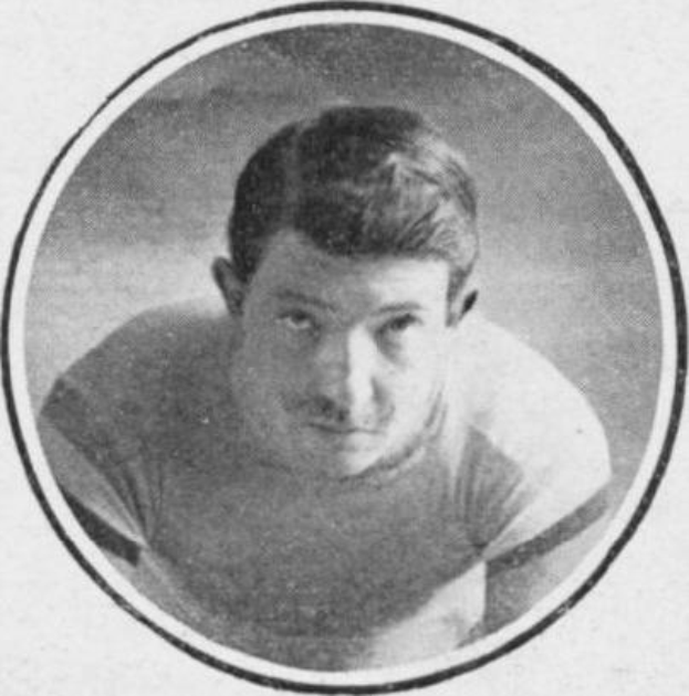 Schwarzes und weißes Foto eines Fußballspielers in einem Trikot mit ernstem Gesichtsausdruck, konzentriertem Blick und kurzen dunklen Haaren vor einem weißen Hintergrund.