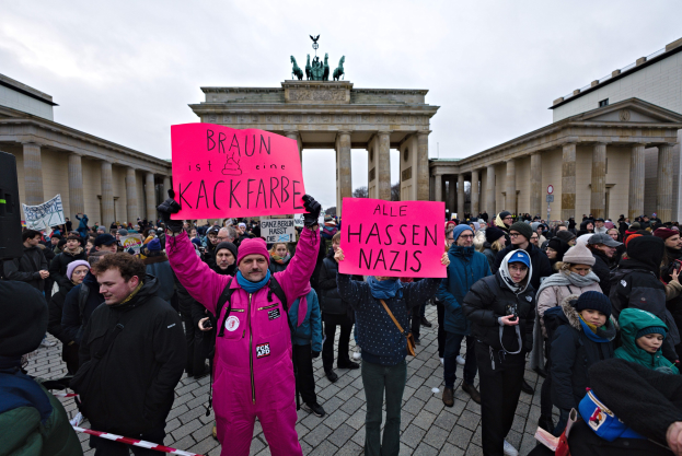 Gruppe von Demonstranten protestiert vor dem Reichstagsgebäude in Berlin mit Schildern gegen die Anti-Nazi-Bewegung der deutschen Regierung.