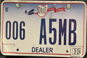 Ein Nummernschild auf der Rückseite eines Autos mit Text und Zahlen.