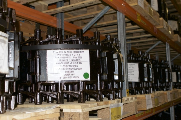 Ein Lagerhaus voller Metallverteilergeschosse und -komponenten auf Holzpaletten, jeweils mit einem Aufkleber versehen.