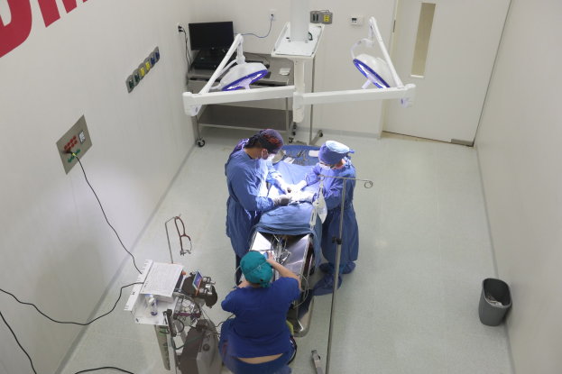 Ein aufgeschlagenes Buch mit dem Titel "Abhandlung über die operative Chirurgie: Beschreibung verschiedener Prozesse der Kunst, alle neuen Operationen" vor einem dunklen Hintergrund.