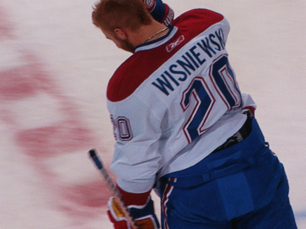 Professioneller Hockey-Spieler in "Wisniewski"-Trikot mit Hockey-Schläger auf dem Eis