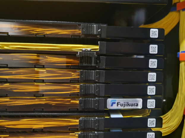 Ein Close-up eines Serverturms in einem Rechenzentrum, mit elektronischen Geräten und Kabeln, die damit verbunden sind und ein Netzwerk bilden.