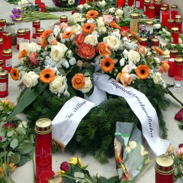 Mahnmal in Berlin, Deutschland mit Blumen und Kerzen vor einer Wand auf dem Boden