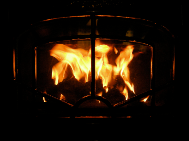 Ein Feuer brennt in einem Kamin mit Holz.