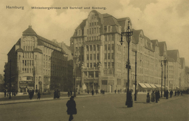 Schwarz-weiß-Foto von Menschen, die eine Straße in Hamburg, Deutschland, entlanggehen, gesäumt von Gebäuden, Straßenlaternen, Lampen und Fahrzeugen unter einem bewölkten Himmel mit Text oben.