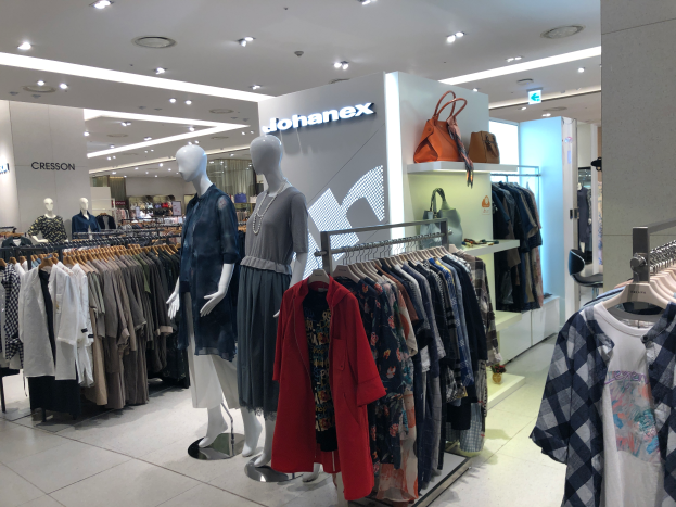Ein Bekleidungsgeschäftsinneres mit Schaufensterpuppen, Kleiderstangen, Handtaschen, Schildern und Deckenleuchten, Located im Mall of Asia, Teil der Johanex-Marke.