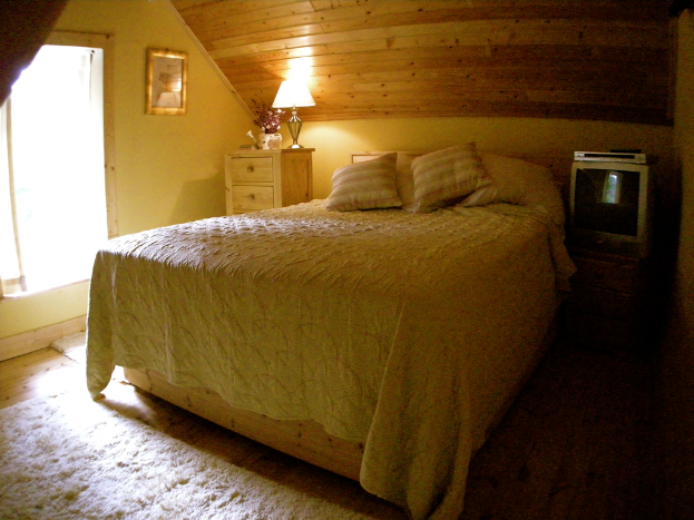 Ein Schlafzimmer mit Bett, Nachttisch und Kleiderschrank.