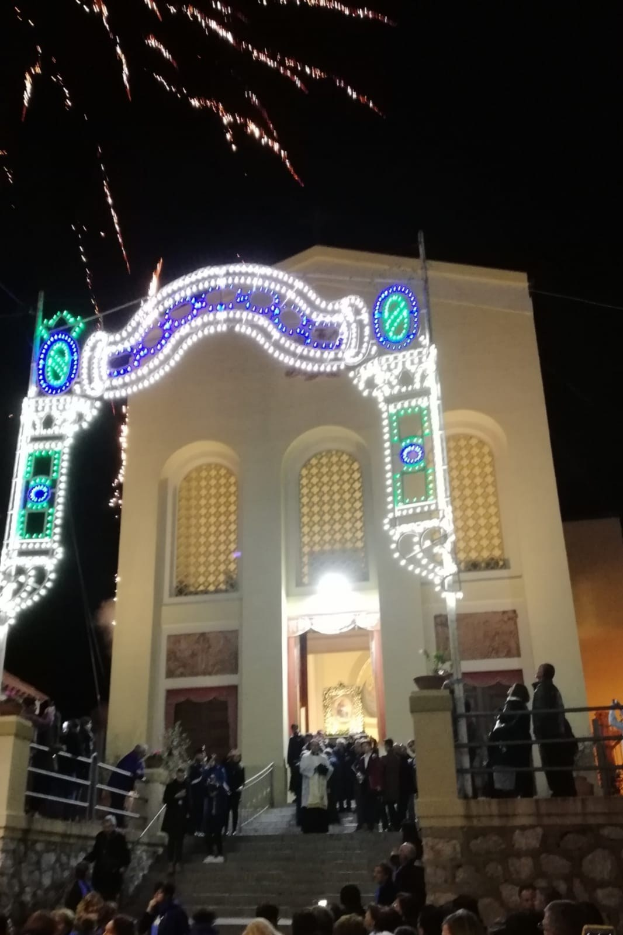 Menschen vor einem Gebäude mit beleuchtetem Torbogen, Treppe und Topfpflanzen bei einer Silvesterfeier