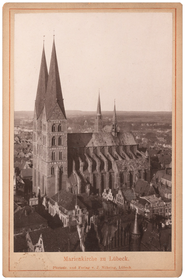 Schwarz-weiß-Foto einer Stadt mit einer Kirche in der Mitte, umgeben von anderen Gebäuden, mit Text unten.