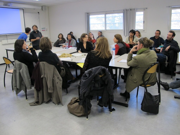 Eine Gruppe von Menschen, die sich unterhält, wobei zwei andere Personen separat stehen und sprechen.