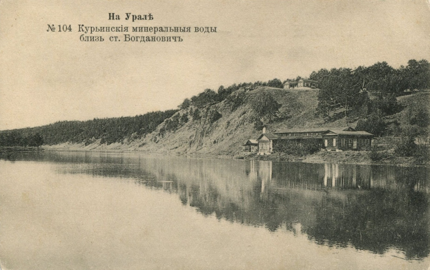 Schwarzes und weißes Foto eines Sees mit einem Haus am Ufer, Bäumen, einem Hügel im Hintergrund und Text oben.