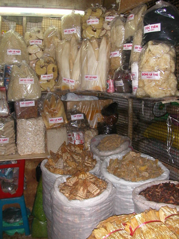 Ein Marktstand mit ordentlich verpackten Lebensmitteln in Tüten und Plastikhauben.