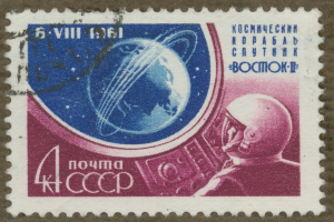 Eine Briefmarke mit einem Mann im Weltraumanzug mit Helm, der einen entschlossenen Ausdruck hat und von der Schrift "Marke" in fetter, weißer Schrift umgeben ist.