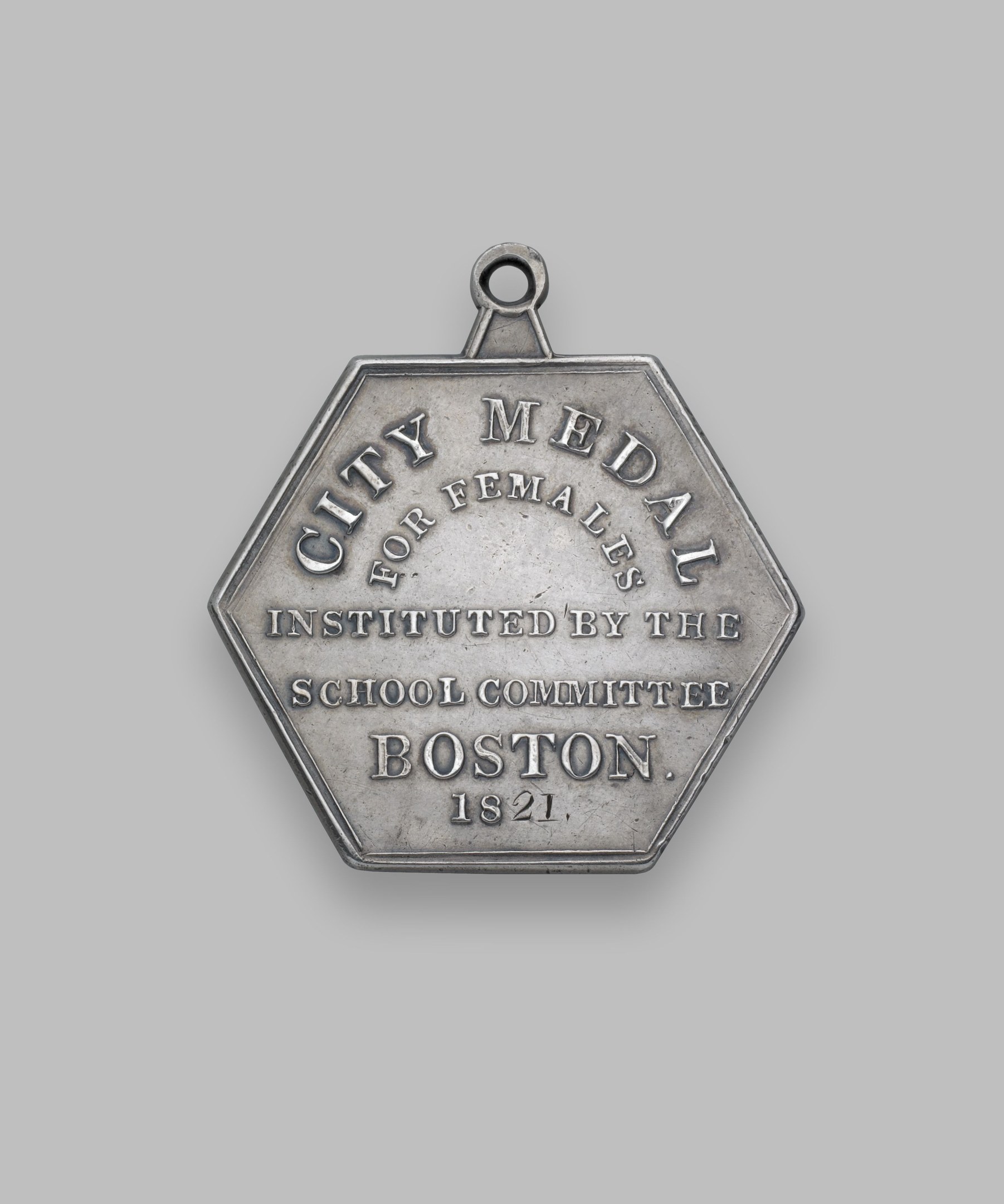 Silberne Medaille mit der Aufschrift 'Stadtmedaille für Frauen' vor einem weißen Hintergrund.