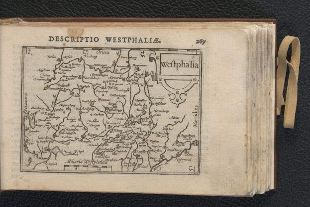 Ein aufgeschlagenes Buch, das eine detaillierte Karte der geographischen Merkmale Westphalens zeigt, liegt auf einer schwarzen Oberfläche.