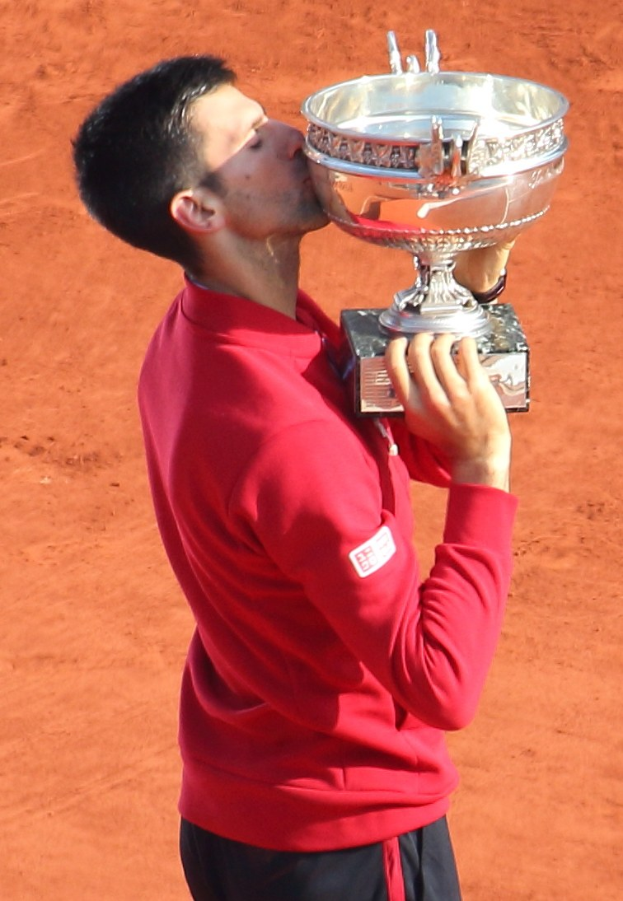 Novak Djokovic hält den French-Open-Pokal nach Sieg gegen Rafael Nadal im Finale der Herren-Einzel, feiert triumphierend.