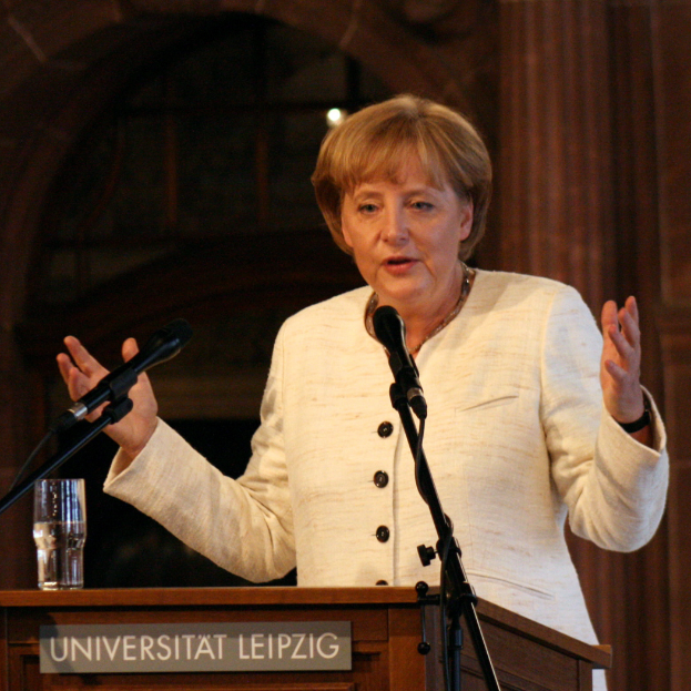 Bundeskanzlerin Angela Merkel hält eine Rede an der Universität Leipzig vor einem Rednerpult mit Mikrofon und einem Glas Wasser.
