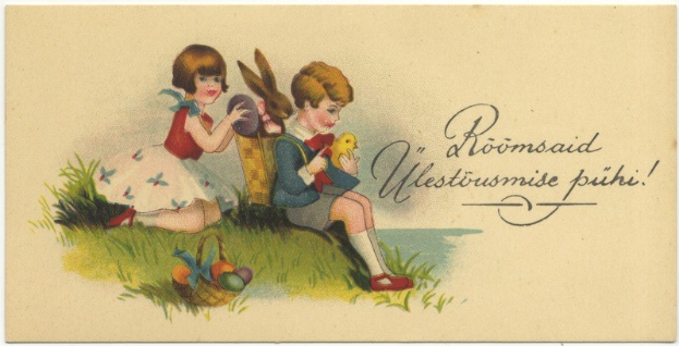 Schwarz-weiß-Postkarte mit zwei Kindern auf dem Gras sitzend, eines hält einen Korb mit Ostereiern, das andere ein Spielzeug, im Hintergrund ein Plakat mit Text.