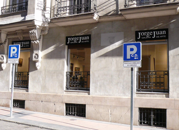 Ein mehrstöckiges Gebäude mit Fenstern, Geländern, Türen und Säulen, das Schilder an Pfosten entlang des Gehwegs und sichtbare Innenobjekte zeigt, die eine belebte Stadtkulisse suggerieren.