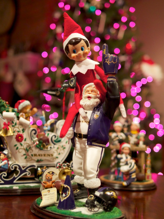 Spielfiguren mit beleuchtetem Weihnachtsbaum im Hintergrund.
