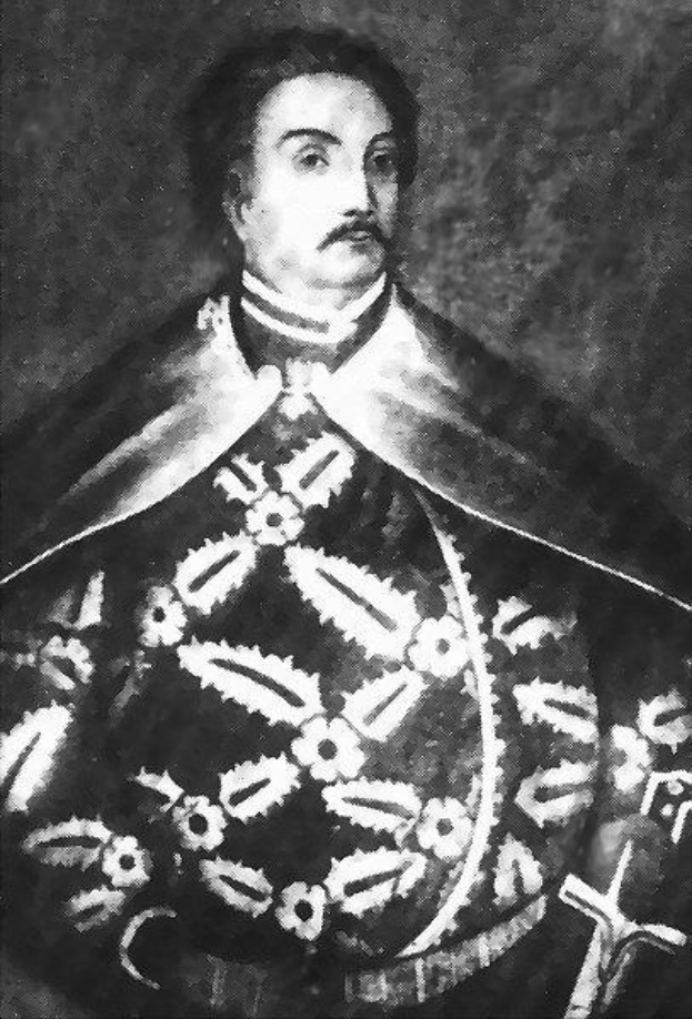 Schwarzes und weißes Foto von Papst Johannes Paul II. in Priesterroben, der eine schwarze Robe mit weißem Kragen und Manschetten trägt und die Hände gefaltet hat, mit ernstem Gesichtsausdruck und direktem Blick.